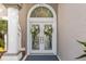 Close up on elegant double front doors with decorative wreaths and an arched window at 9322 Wellington Park Cir, Tampa, FL 33647