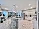 Well-lit kitchen featuring a kitchen island with barstool seating, granite countertops, and stainless steel appliances at 9322 Wellington Park Cir, Tampa, FL 33647