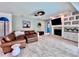 Inviting living room with a cozy fireplace, built-in shelving, tile flooring, and comfortable leather seating at 9322 Wellington Park Cir, Tampa, FL 33647