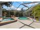 Enclosed pool and spa area with seating and privacy landscaping at 9322 Wellington Park Cir, Tampa, FL 33647