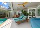 Inviting screened-in pool area with lounge chairs, ceiling fans, and patio at 9322 Wellington Park Cir, Tampa, FL 33647