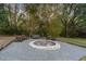 Backyard fire pit area with stone border, seating, swing, and gravel, perfect for outdoor relaxation at 9801 Pine Leaf Ln, Dade City, FL 33525