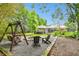 Scenic backyard features a cozy fire pit area, swing, chairs, and lush greenery for relaxing moments at 9801 Pine Leaf Ln, Dade City, FL 33525
