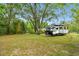 Spacious backyard with lush greenery, mature trees, and a camper adding to the property's appeal at 9801 Pine Leaf Ln, Dade City, FL 33525