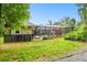 Expansive backyard showcasing a screened-in patio with lounge chairs and dining area overlooking lush green space at 9801 Pine Leaf Ln, Dade City, FL 33525