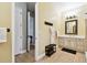 Bathroom featuring a white vanity, coat hooks with a bathrobe and views into another room at 9801 Pine Leaf Ln, Dade City, FL 33525