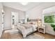 Bedroom featuring shiplap accent wall, a bed with a gray headboard and light from two windows at 9801 Pine Leaf Ln, Dade City, FL 33525