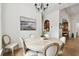 Formal dining room with a round table, decorative painting, and hardwood floors at 9801 Pine Leaf Ln, Dade City, FL 33525