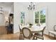 Dining area featuring wood floors, chandelier, and views of the backyard at 9801 Pine Leaf Ln, Dade City, FL 33525