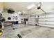 Spacious garage with painted floor, multiple garage doors, storage, and visible tool storage at 9801 Pine Leaf Ln, Dade City, FL 33525