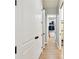 Hallway with hardwood floors and doors opening to a walk-in closet with custom shelving at 9801 Pine Leaf Ln, Dade City, FL 33525