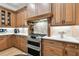 Gourmet kitchen features a stainless steel double oven and custom cabinetry with tile backsplash at 9801 Pine Leaf Ln, Dade City, FL 33525