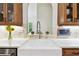 Farmhouse sink with chrome faucet, light tile backsplash and wood cabinetry at 9801 Pine Leaf Ln, Dade City, FL 33525
