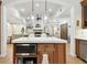 Open floor plan view of the kitchen island with microwave and seating and view to the living room at 9801 Pine Leaf Ln, Dade City, FL 33525