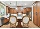 Well-lit kitchen features wood cabinetry, stainless steel appliances and two pendant lights above the island at 9801 Pine Leaf Ln, Dade City, FL 33525