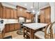 Spacious kitchen with wood cabinets, stainless steel appliances, large island and pendant lighting at 9801 Pine Leaf Ln, Dade City, FL 33525