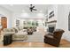 Spacious living room with fireplace, hardwood floors, ceiling fan, and view of outdoor pool at 9801 Pine Leaf Ln, Dade City, FL 33525