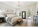Bright main bedroom with a chandelier, accent art, and access to the backyard at 9801 Pine Leaf Ln, Dade City, FL 33525
