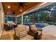 Comfortable covered patio leading to a screened pool with waterfalls, plenty of seating and landscaping at 9801 Pine Leaf Ln, Dade City, FL 33525