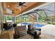 Covered patio featuring comfortable seating, a ceiling fan, and a view of the screened-in pool area at 9801 Pine Leaf Ln, Dade City, FL 33525