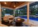 Relaxing screened-in pool area with a fire pit table and swing seating for outdoor gatherings and serene evenings at 9801 Pine Leaf Ln, Dade City, FL 33525