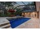 Inviting in-ground pool with stone accents, complemented by lounge and dining areas for outdoor enjoyment at 9801 Pine Leaf Ln, Dade City, FL 33525
