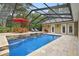 Stunning in-ground pool with stone accents, complemented by lounge and dining areas for outdoor entertainment at 9801 Pine Leaf Ln, Dade City, FL 33525