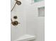 Close-up of bathroom shower featuring white subway tile, corner seating, and bronze fixtures at 9801 Pine Leaf Ln, Dade City, FL 33525