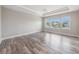 Bright, empty bedroom with tray ceilings, wood floors, and large windows that provide ample natural light at 1018 Tracey Ann Loop, Seffner, FL 33584