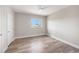 Bright, empty bedroom featuring neutral walls, wood floors, a ceiling fan, and a window for natural light at 1018 Tracey Ann Loop, Seffner, FL 33584