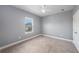 Empty bedroom featuring gray walls, carpet flooring, one window, and a ceiling fan at 1018 Tracey Ann Loop, Seffner, FL 33584