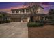 Inviting two-story home at sunset featuring a well-manicured lawn, stone accents, and a convenient two-car garage at 1018 Tracey Ann Loop, Seffner, FL 33584