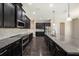 Spacious kitchen featuring dark cabinetry, stainless steel appliances, granite countertops, and a stylish backsplash at 1018 Tracey Ann Loop, Seffner, FL 33584
