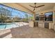This pool features a screened-in area with a kitchen including grill, sink, and beverage cooler at 1018 Tracey Ann Loop, Seffner, FL 33584