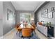 Stylish dining room with a large window, modern sideboard and rustic wood table at 10602 Rochester Way, Tampa, FL 33626