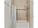 Clean bathroom with bathtub/shower featuring patterned shower curtain, tile backsplash and showerhead at 10602 Rochester Way, Tampa, FL 33626