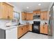 Well-lit kitchen featuring wooden cabinets, stainless steel appliances, and white subway tile backsplash at 10705 Knollsway Ct, Tampa, FL 33625