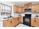 Classic kitchen featuring wooden cabinets, subway tile backsplash, and modern black appliances at 10705 Knollsway Ct, Tampa, FL 33625