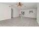 Bright, spacious living room with tile flooring, a ceiling fan, and double doors leading to the backyard at 10705 Knollsway Ct, Tampa, FL 33625