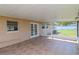 Relaxing covered patio with tiled floor, offering an outdoor space with backyard views at 10705 Knollsway Ct, Tampa, FL 33625