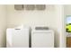 Laundry room featuring white washer and dryer, a storage shelf, and a neutral color scheme at 10801 Fort White Ct, Tampa, FL 33647