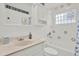 A brightly lit bathroom with a tub and shower combo, vanity, and glass block window feature at 11777 90Th Ave, Seminole, FL 33772