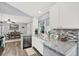 Stylish kitchen featuring granite countertops, stainless steel appliances, and a view into the adjacent dining area at 11777 90Th Ave, Seminole, FL 33772