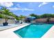 Backyard swimming pool and patio area with table, chairs, spa, and palms at 11777 90Th Ave, Seminole, FL 33772