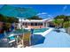 Inviting backyard pool area, featuring a colorful dining set and lounge chairs at 11777 90Th Ave, Seminole, FL 33772