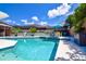 Beautiful backyard pool and patio area with a table, chairs, spa, and palms at 11777 90Th Ave, Seminole, FL 33772