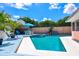 Backyard swimming pool and patio area with table, chairs, and palm tree at 11777 90Th Ave, Seminole, FL 33772
