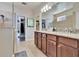 Main bathroom with dual sinks, granite counters, walk-in closets, and tile floors at 12664 Flatwood Creek Dr, Gibsonton, FL 33534