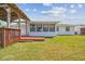 Back exterior of house featuring a large lawn, deck, and covered wooden area at 13617 Frances Ave, Hudson, FL 34667