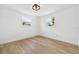 Well-lit room with hardwood floors, white walls, and two windows, providing a bright and airy atmosphere at 13617 Frances Ave, Hudson, FL 34667